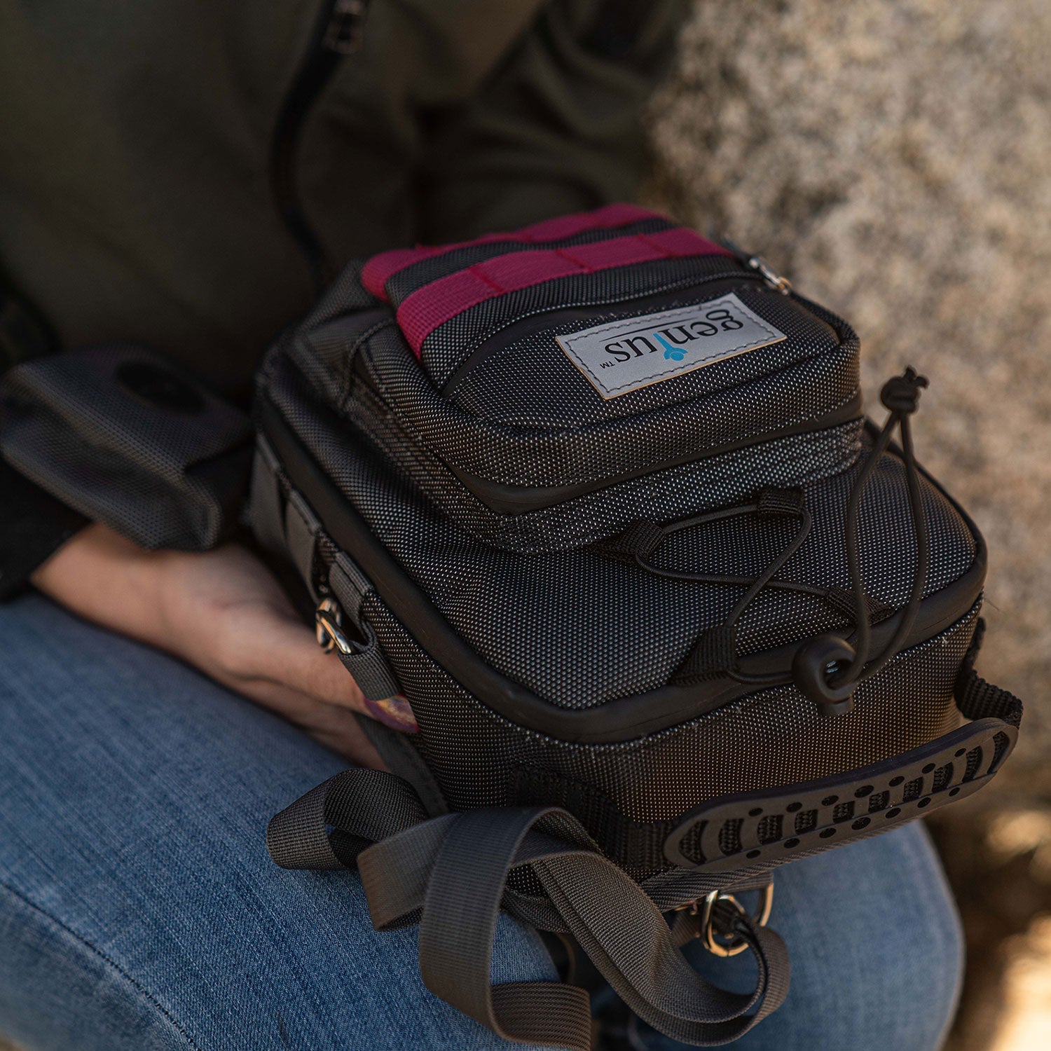 a person holding a black and red bag