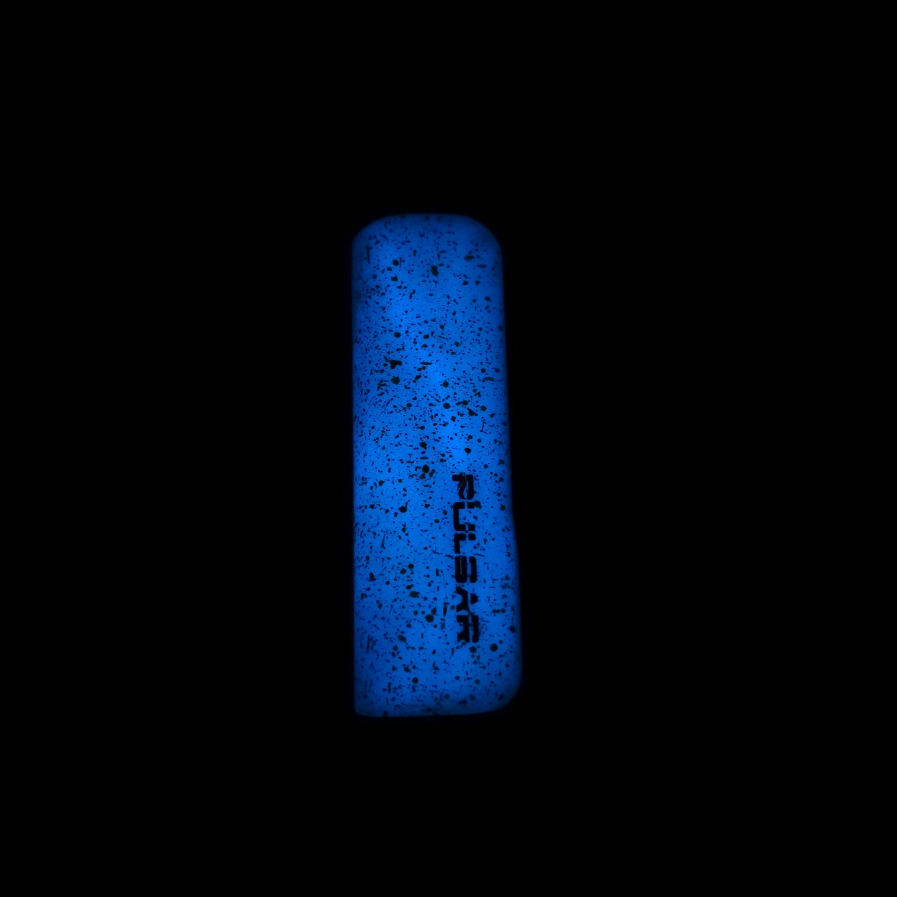 a blue lighter lit up in the dark