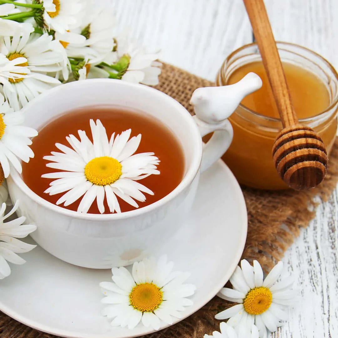 a cup of tea with daisies on a saucer