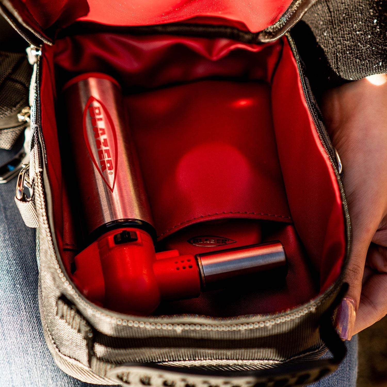 a person holding a red bag with a cell phone in it