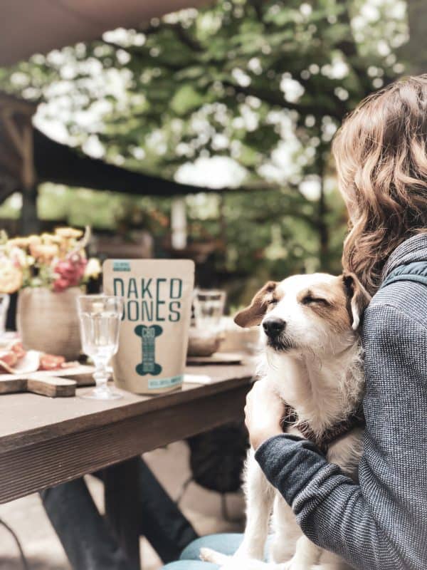 a woman sitting at a table holding a dog