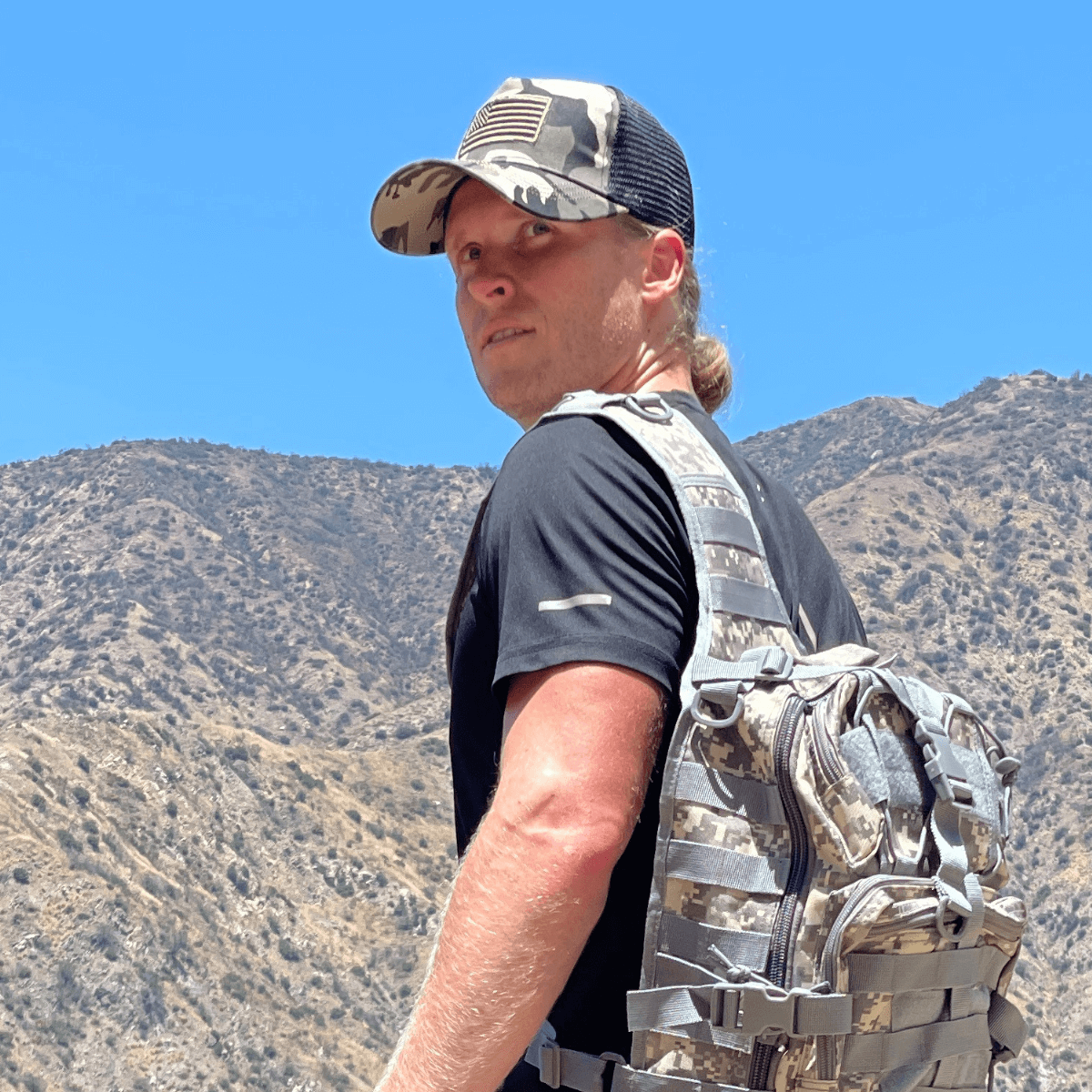 a man with a backpack in front of a mountain