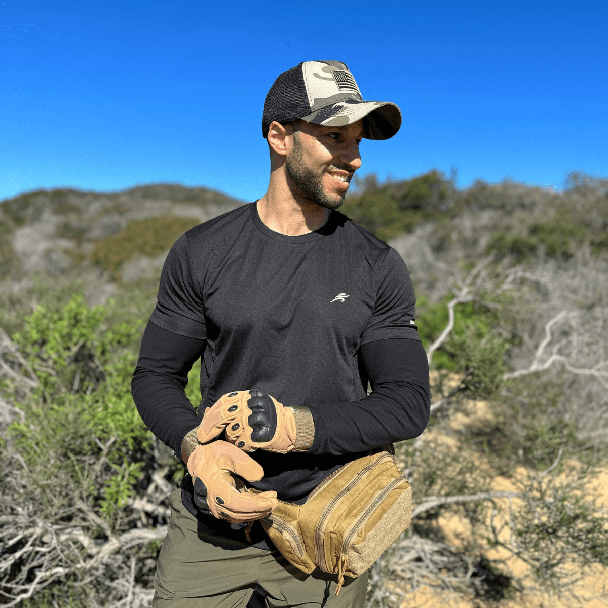 a man in a black shirt and hat holding a baseball glove