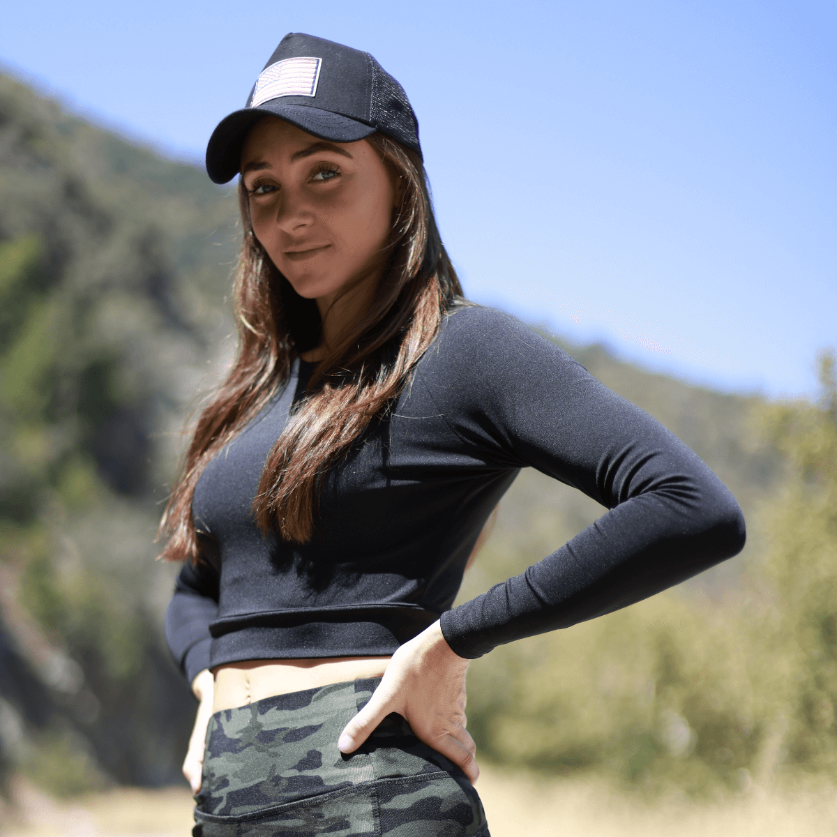 a woman in a black shirt and camo shorts