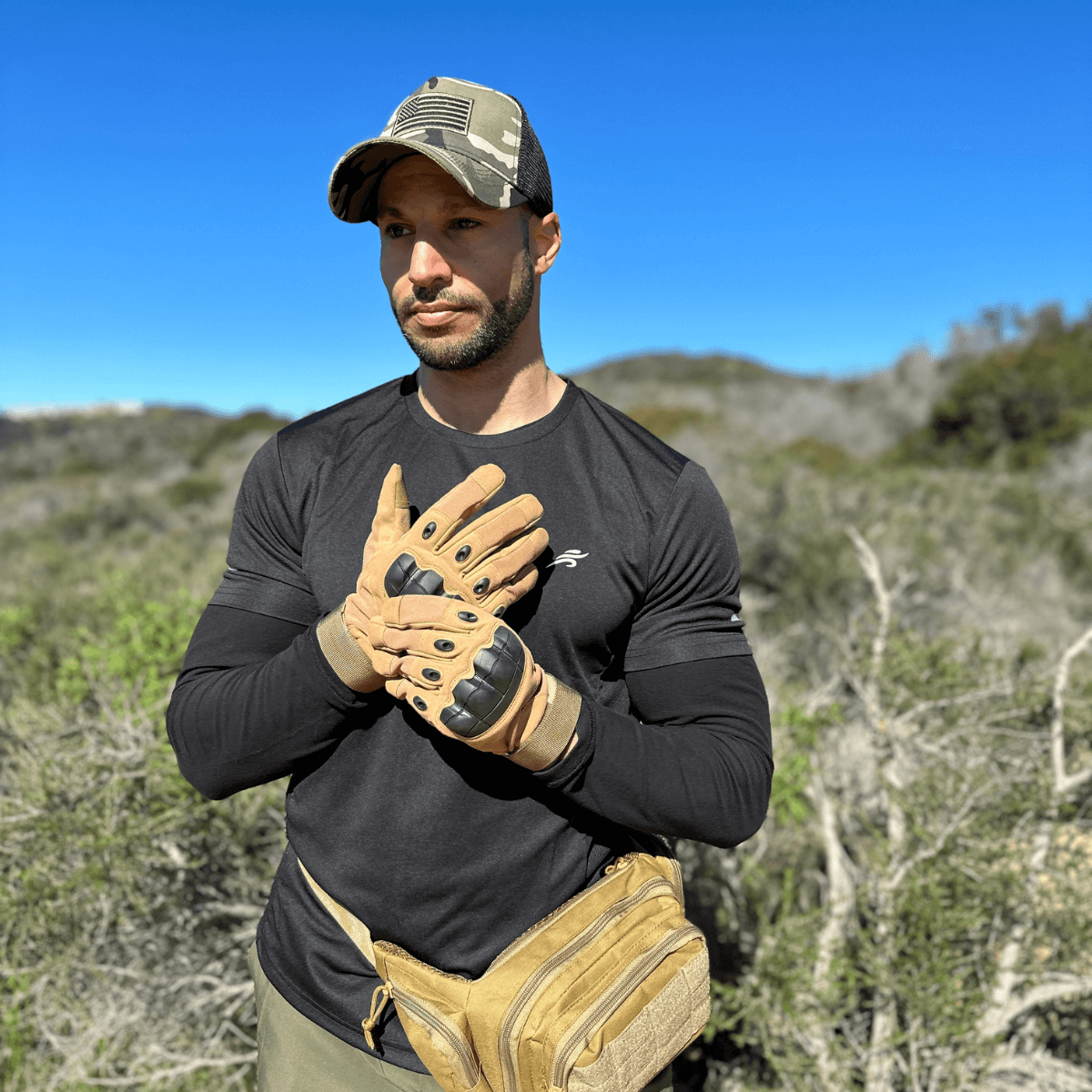 a man in a hat and gloves standing in a field